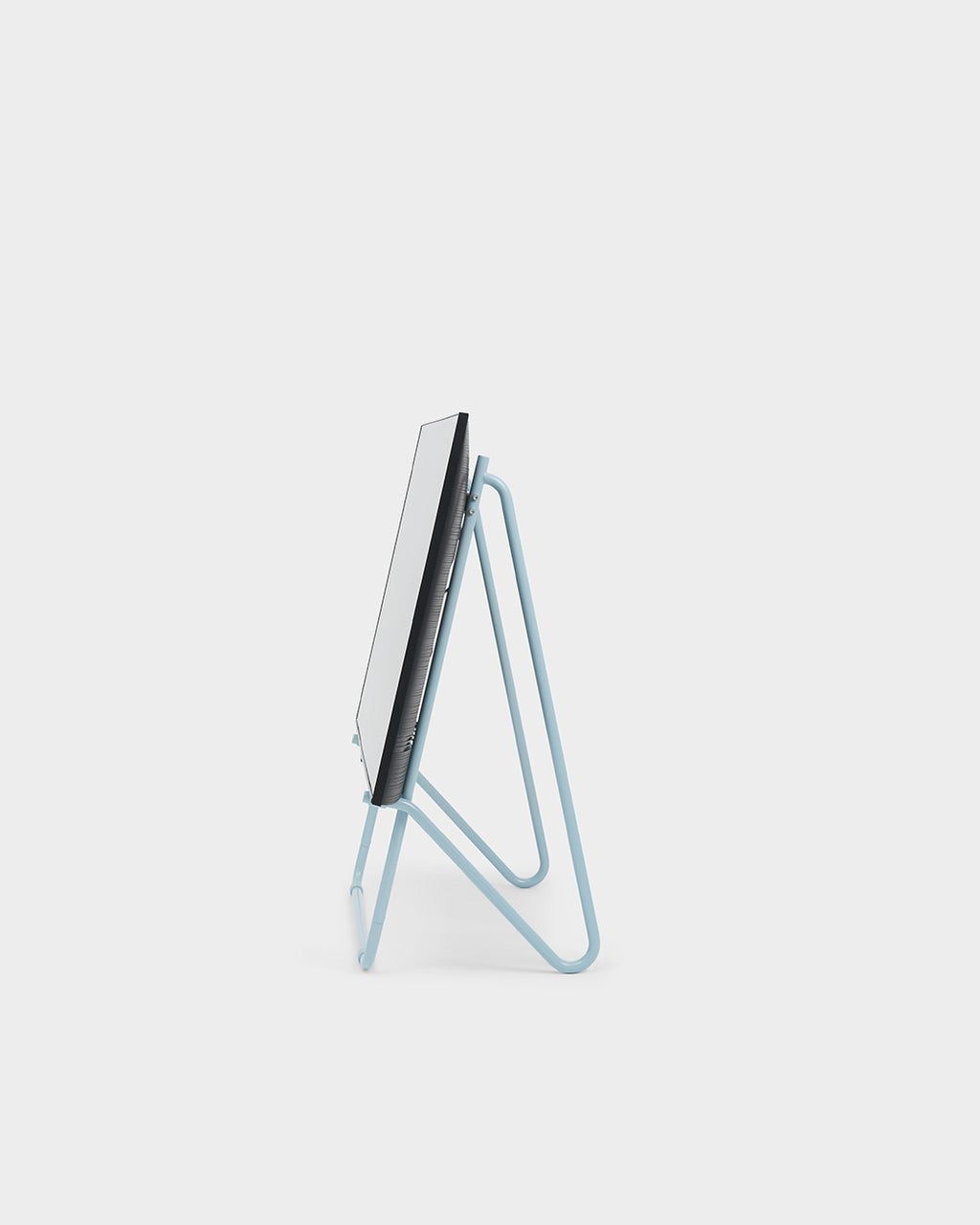 Vista laterale del supporto Bloom in Powder Blue (Stands Low) con schermo montato, packshot in studio su fondo neutro