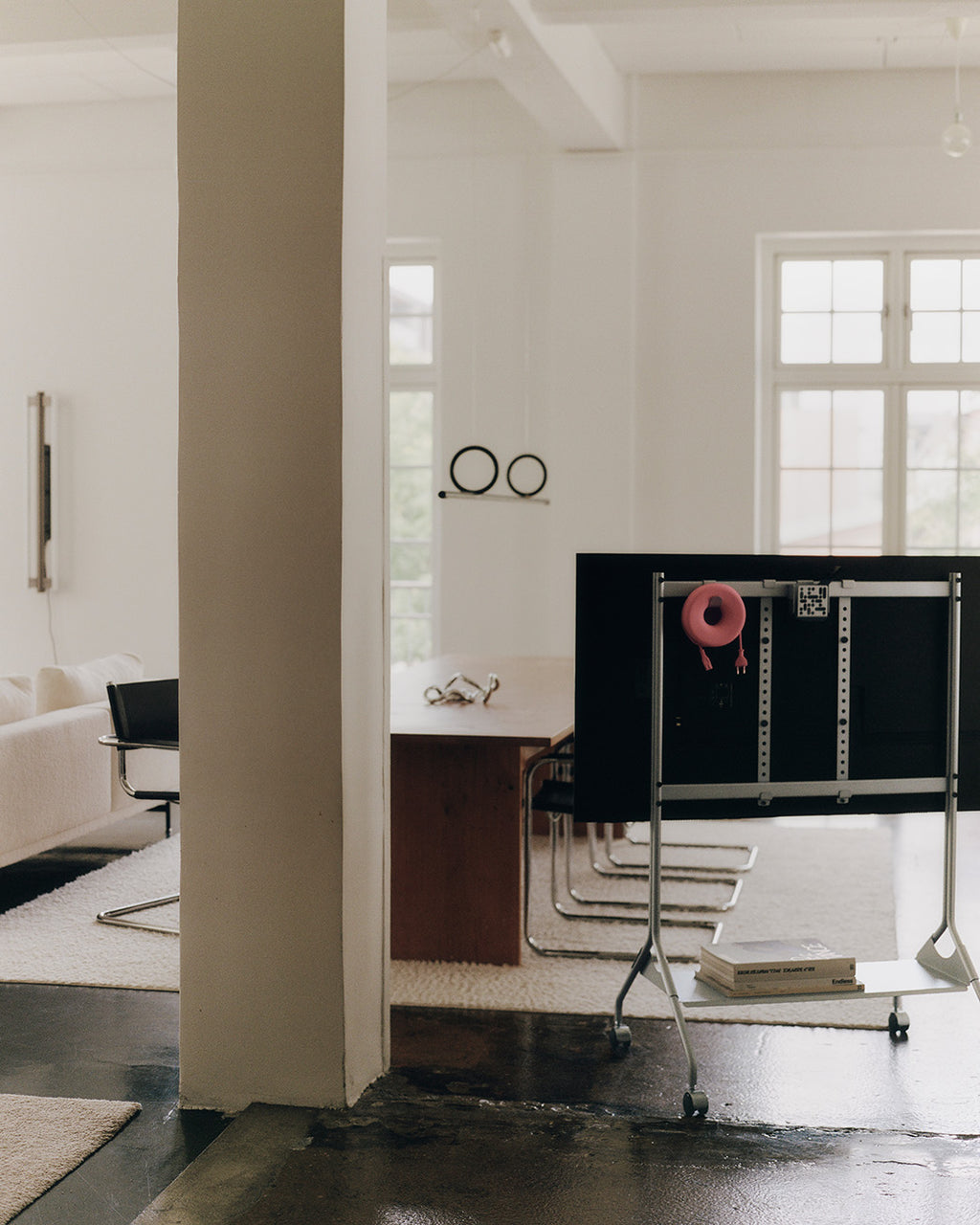 Moon Tall in Cloudy Silver con TV montata, vista posteriore su ruote in un loft luminoso con parquet scuro